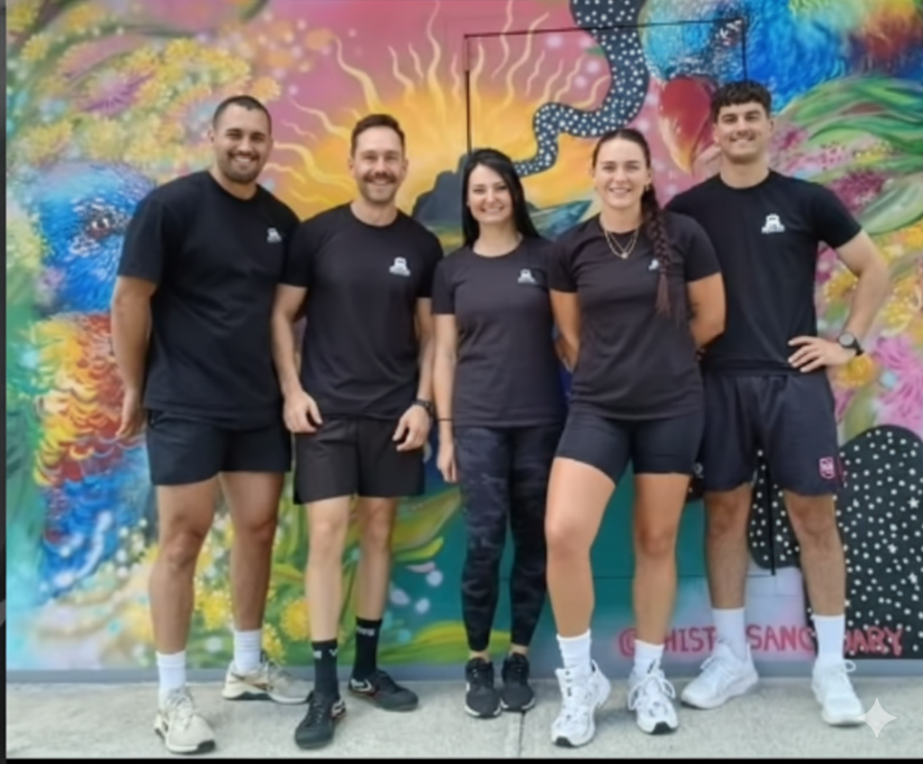 Riddlock team standing together in a park, Infront of a Murial