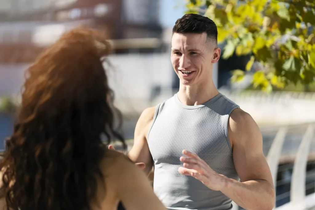 Caucasian man and woman sportive couple speaking together at street. Man explaining something to the woman