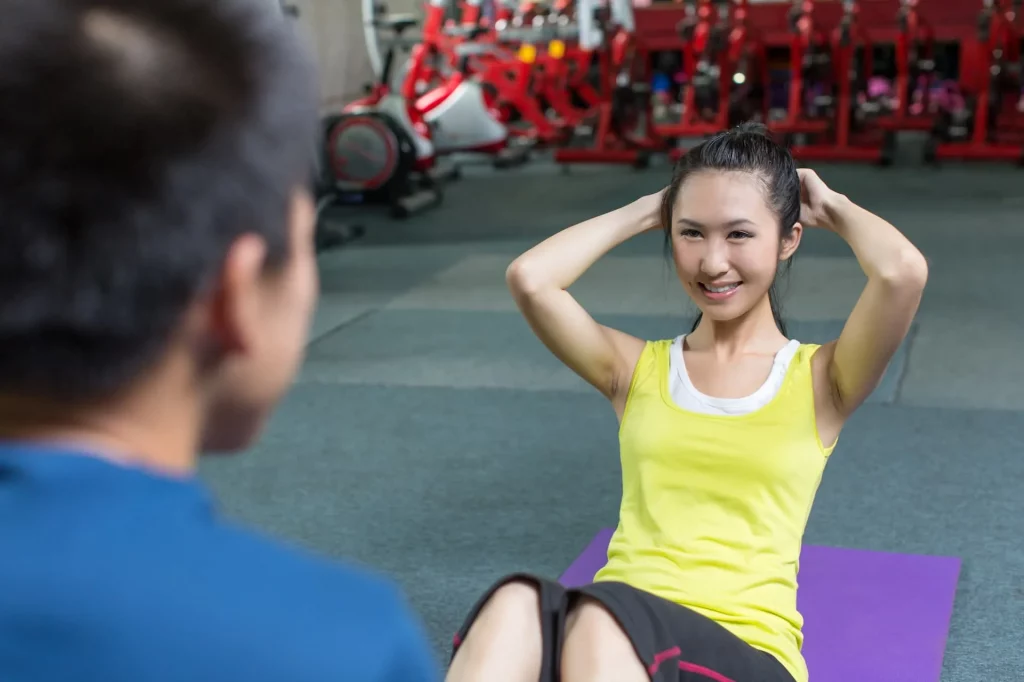 asian woman doing crunches at the gym