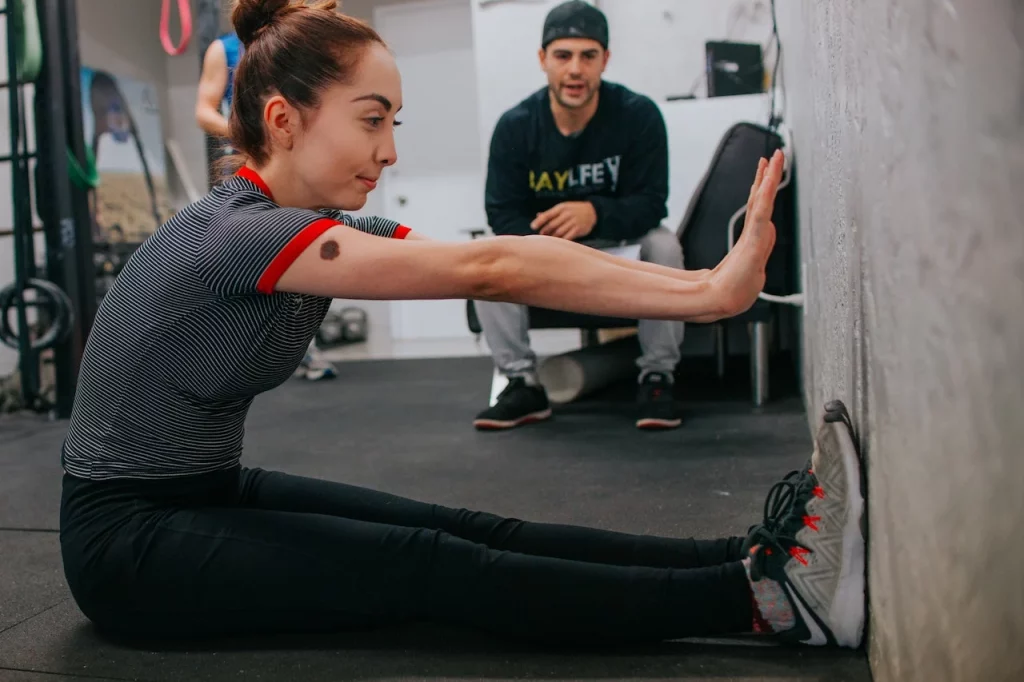 personal trainer helping woman work out